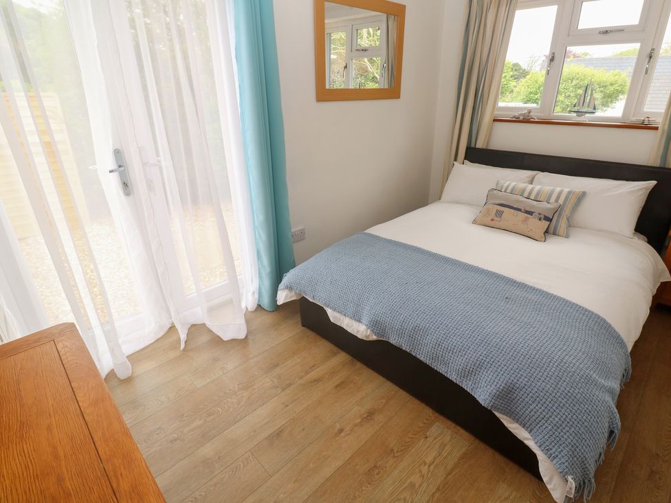 A bedroom with a bed and mirror at Tinners Way in Tresowes near Ashton