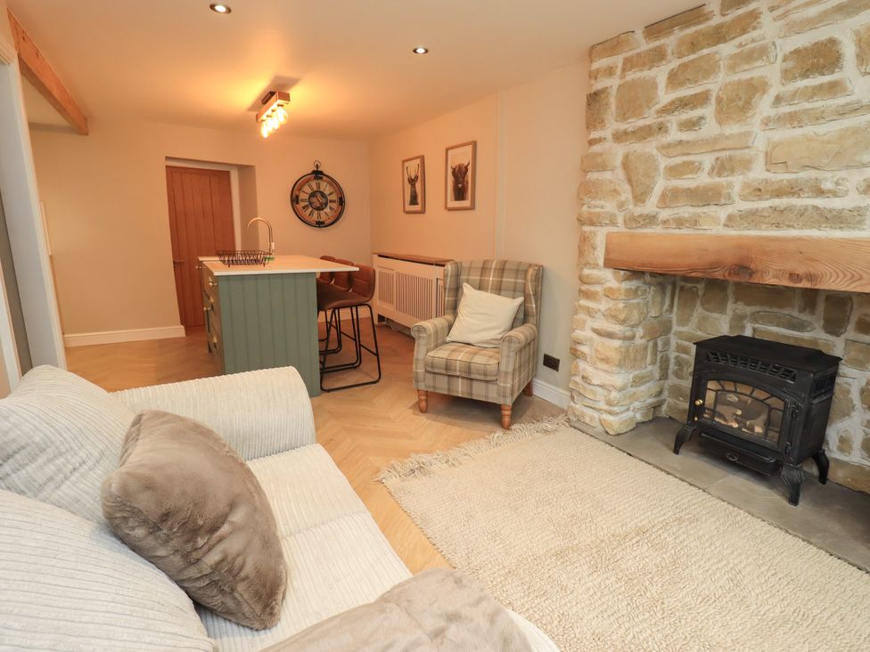 A living room with a sofa and armchair at 7 Milnthorpe Road Holme near Burton-In-Kendal