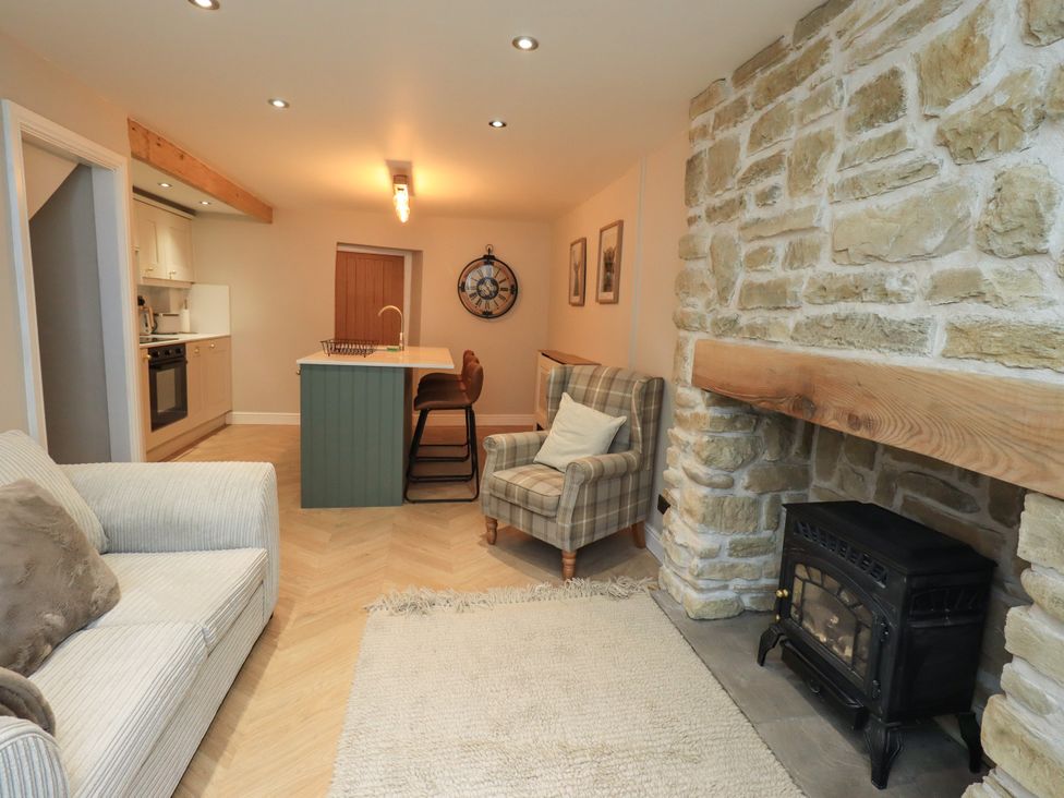 A living room with a sofa and fireplace at 7 Milnthorpe Road in Holme near Burton-In-Kendal