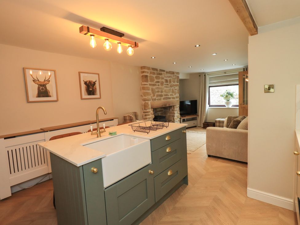 A kitchen with a sink and kitchen island at 7 Milnthorpe Road in Holme near Burton-In-Kendal