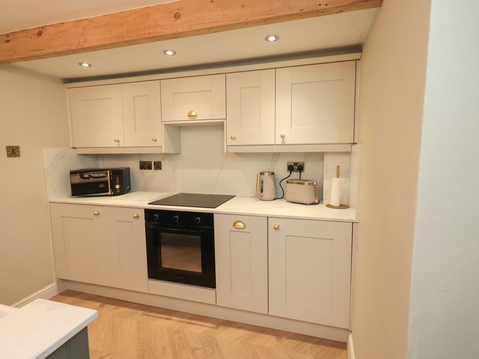 A kitchen with cabinets, microwave, oven, hob, and toaster at 7 Milnthorpe Road Holme near Burton-In-Kendal