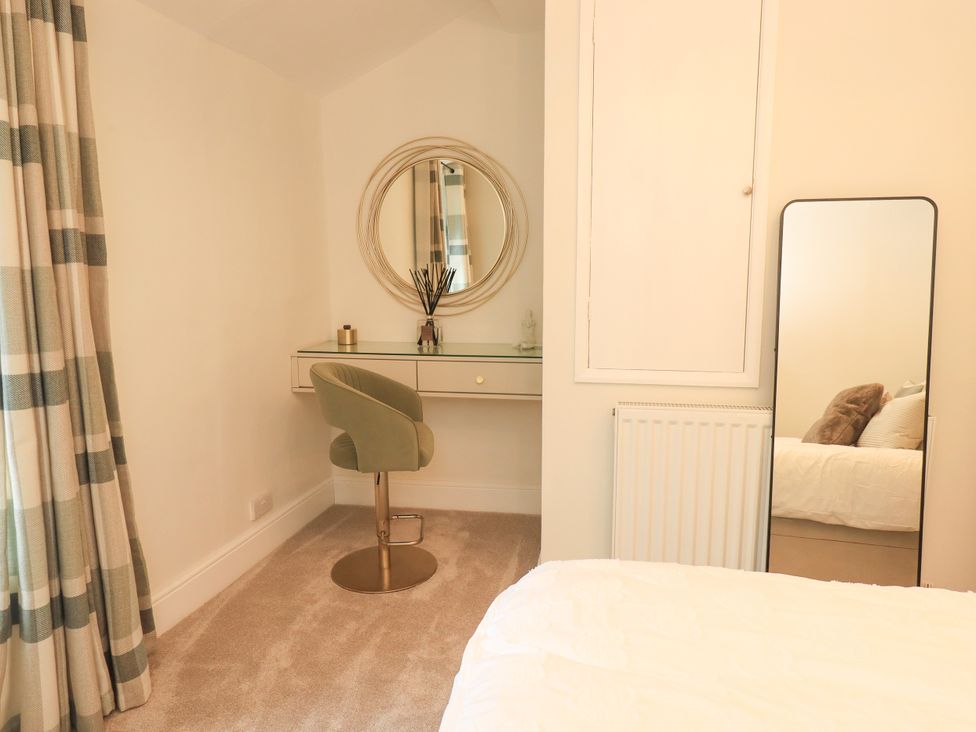 A bedroom with a desk and mirror at 7 Milnthorpe Road in Holme near Burton-In-Kendal