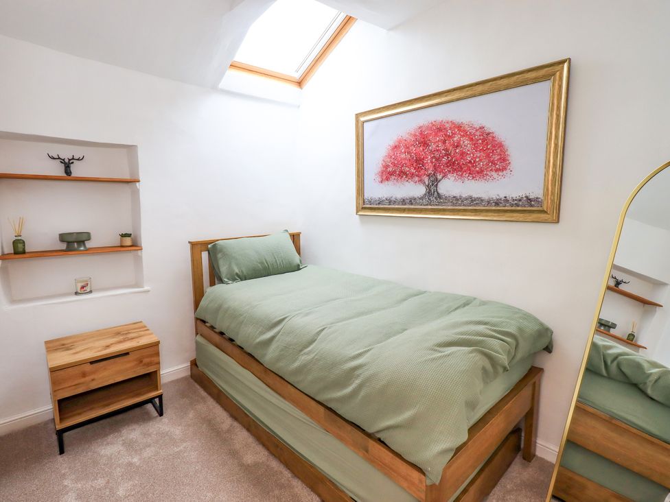 A bedroom with a single bed and a painting at 7 Milnthorpe Road Holme near Burton-In-Kendal
