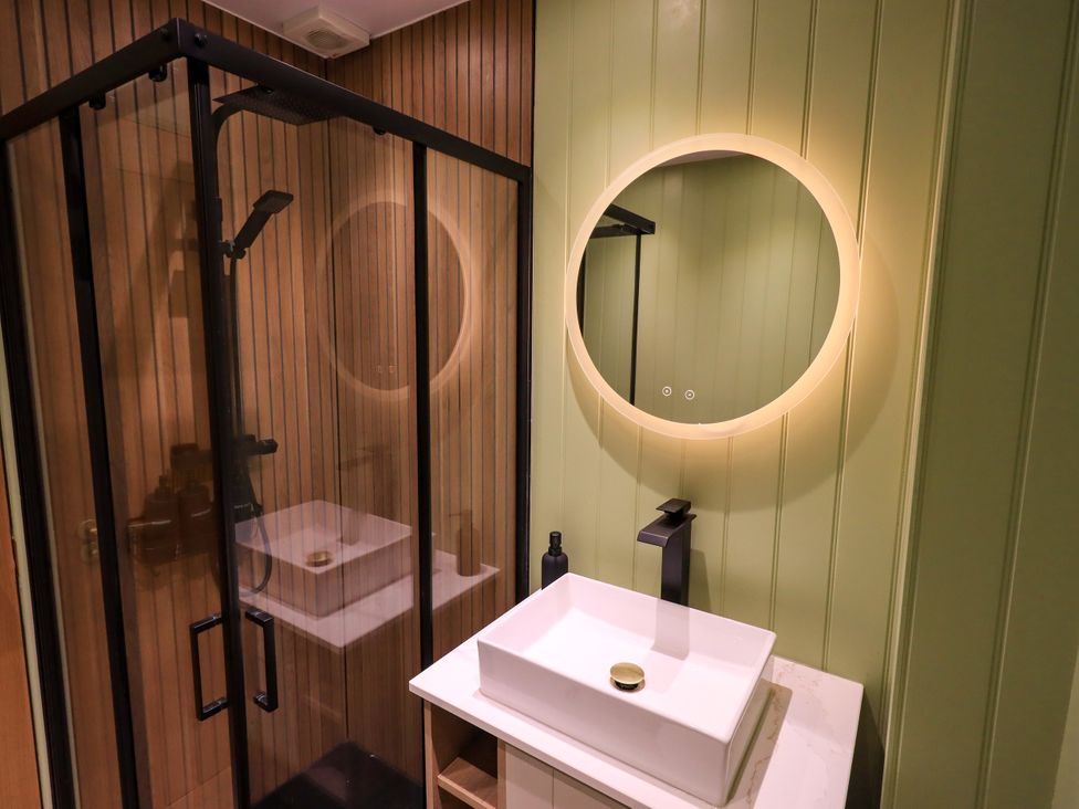 A bathroom with a shower and sink at 7 Milnthorpe Road Holme near Burton-In-Kendal