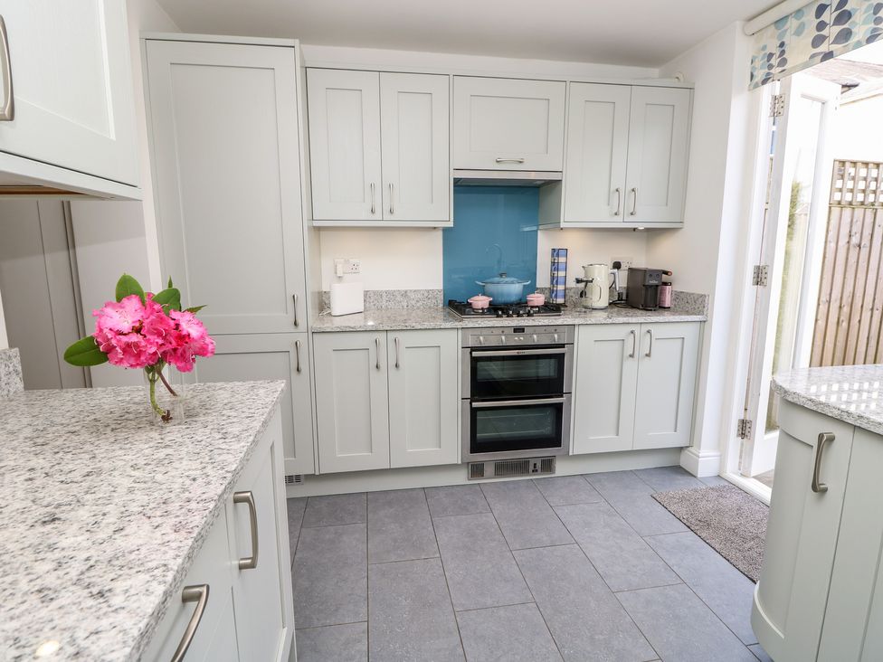 A kitchen with cabinets and appliances at Cobblers Cottage Lymington