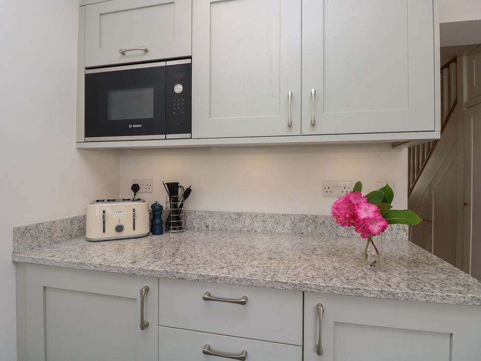 A kitchen counter with a toaster and microwave at Cobblers Cottage in Lymington