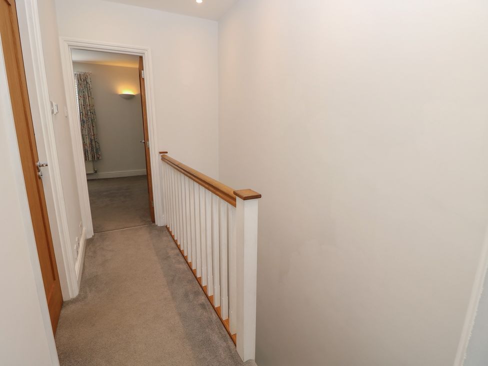 A hallway with stairs and doors at Cobblers Cottage in Lymington