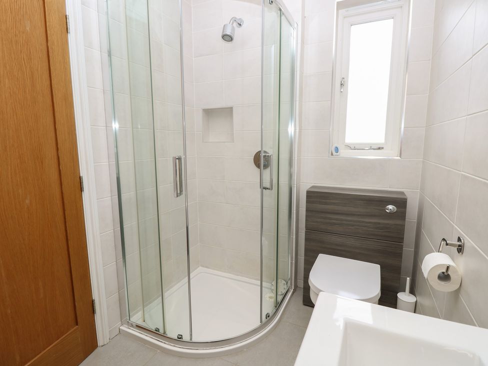 A bathroom featuring a shower, toilet and sink at Cobblers Cottage in Lymington