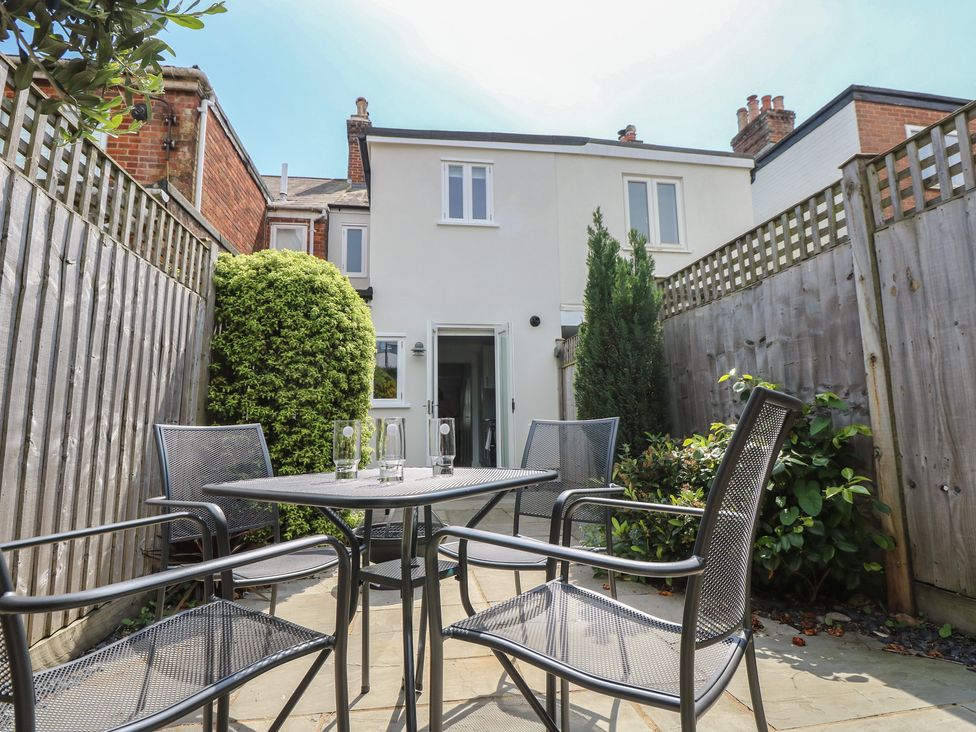 A garden area with a table and chairs at Cobblers Cottage in Lymington