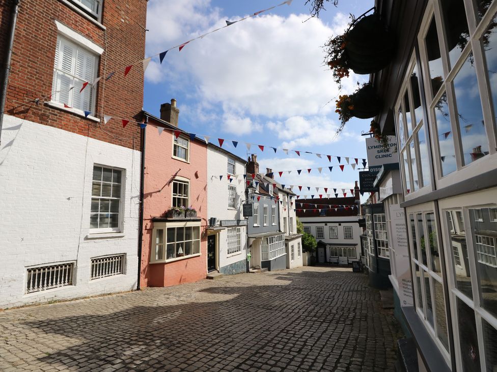 A street lined with buildings and bunting at Cobblers Cottage in Lymington