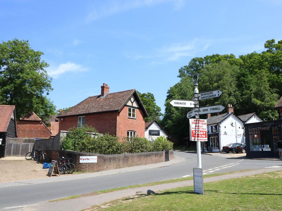 An outdoor view of a street with houses and a signpost at Cobblers Cottage in Lymington