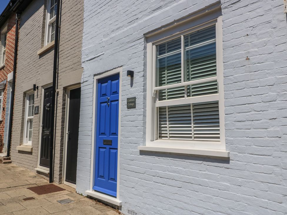 Exterior view of Cobblers Cottage in Lymington with a blue door and window