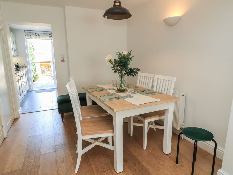 A dining room with a table and chairs at Cobblers Cottage in Lymington