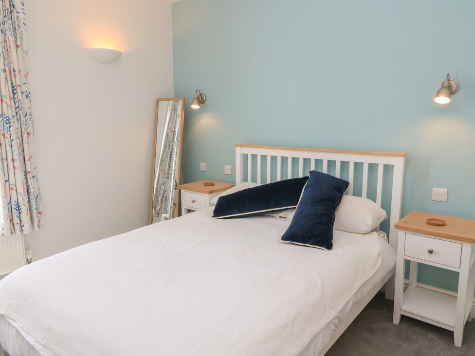 A bedroom with a bed and a bedside table at Cobblers Cottage in Lymington