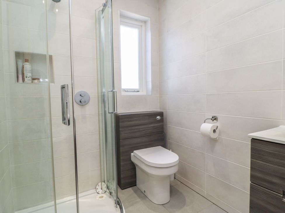 A bathroom with a shower, toilet, and sink at Cobblers Cottage in Lymington