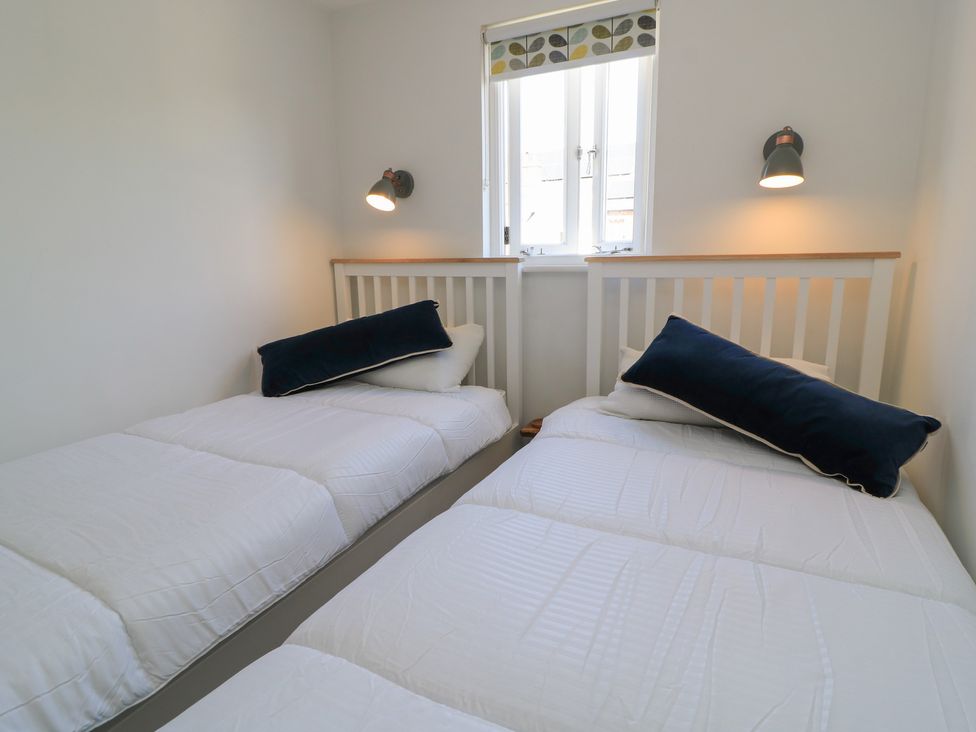 A bedroom with two beds and a window at Cobblers Cottage in Lymington