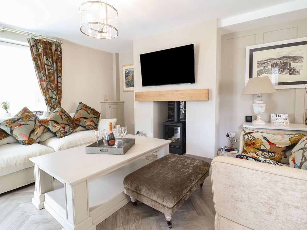 A living room with a sofa, coffee table, and television at 2 Llewelyn Street in Conwy