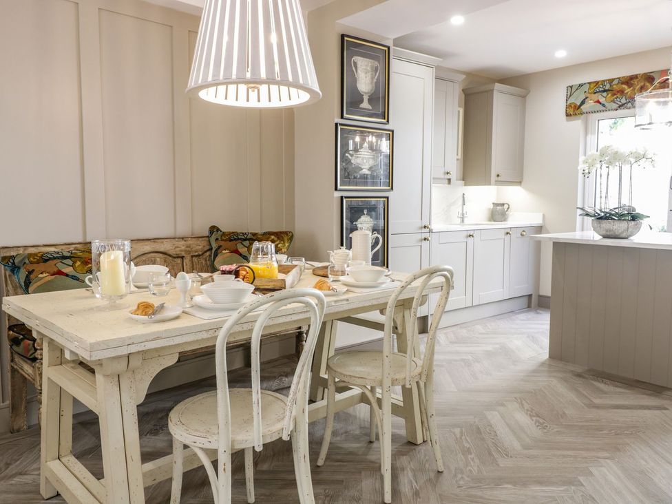 A kitchen with a dining area featuring a table and chairs at 2 Llewelyn Street Conwy