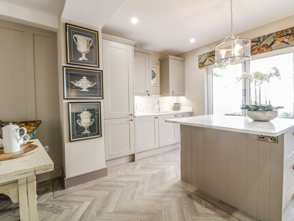 A kitchen with cabinets, island, and window at 2 Llewelyn Street in Conwy