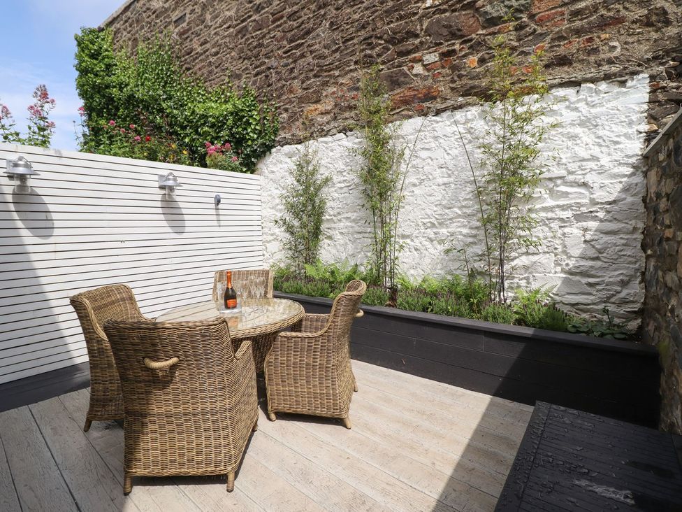 An outdoor seating area with a table and wine bottle at 2 Llewelyn Street, Conwy