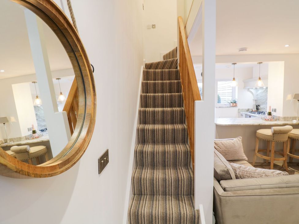A staircase leading to an upper level near the kitchen and living area at 8 Crown Lane in Conwy
