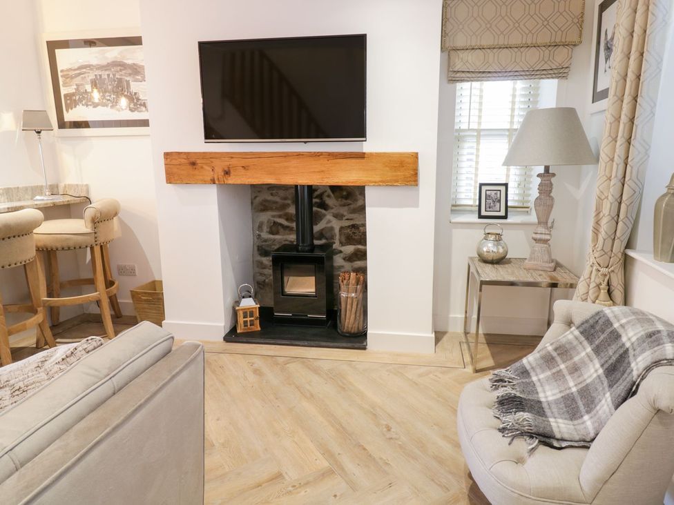 A living room with a fireplace and television at 8 Crown Lane in Conwy