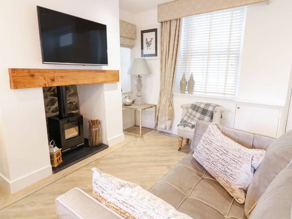 A living room with a sofa and a television at 8 Crown Lane Conwy