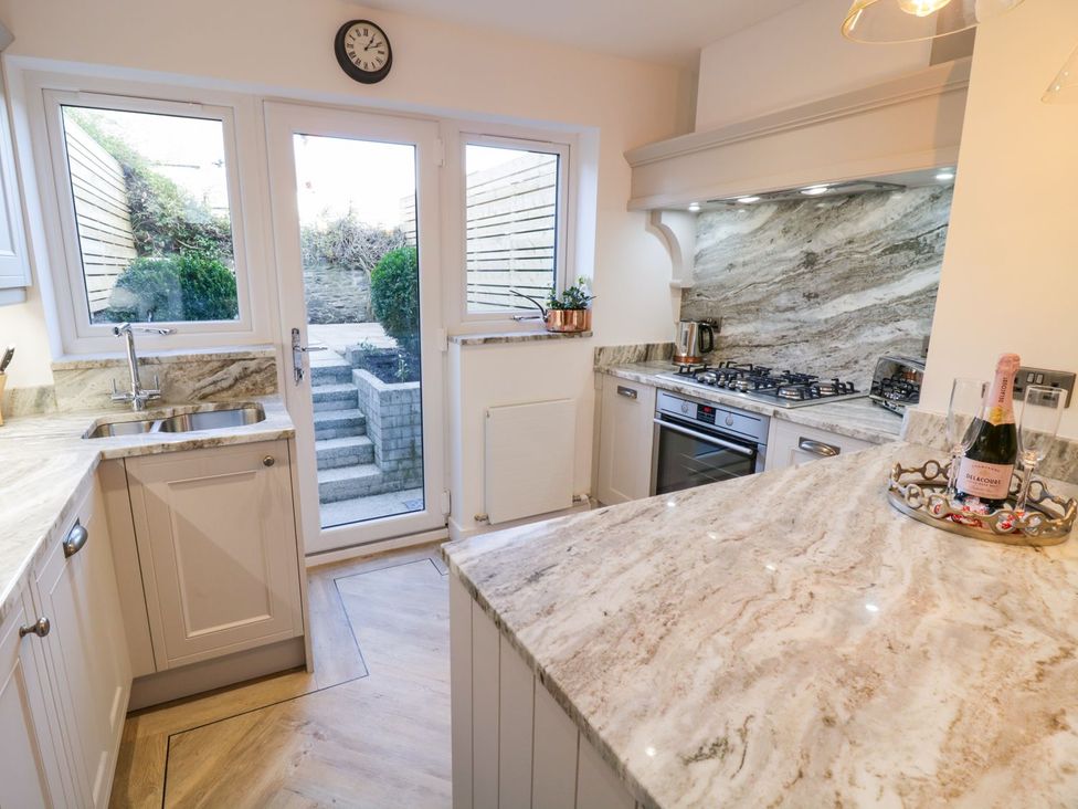 A kitchen with a window and steps leading outside at 8 Crown Lane Conwy