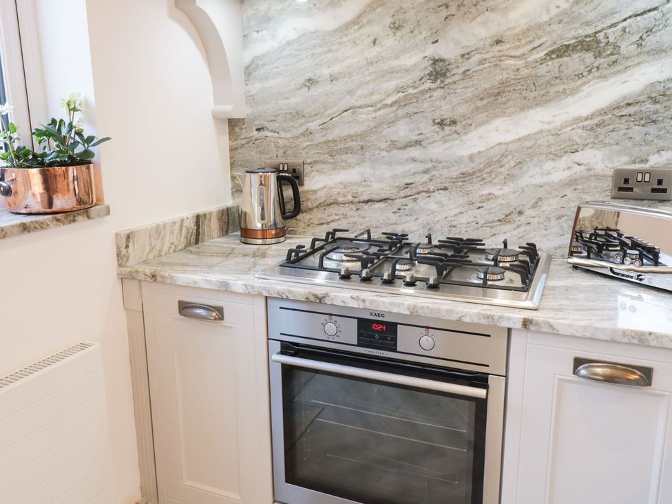 A kitchen with a stove and kettle at 8 Crown Lane, Conwy