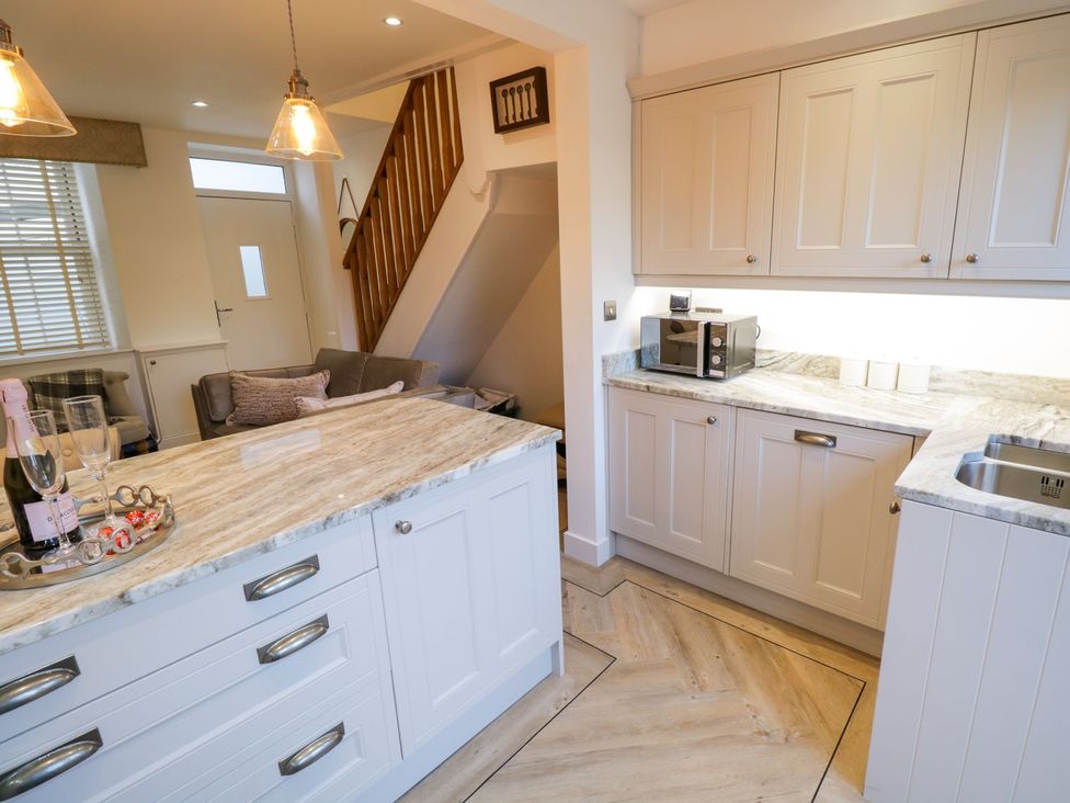 A kitchen with white cabinets and an island at 8 Crown Lane in Conwy