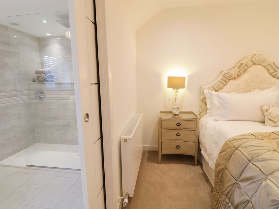 A bedroom with a shower and bedside table at 8 Crown Lane Conwy