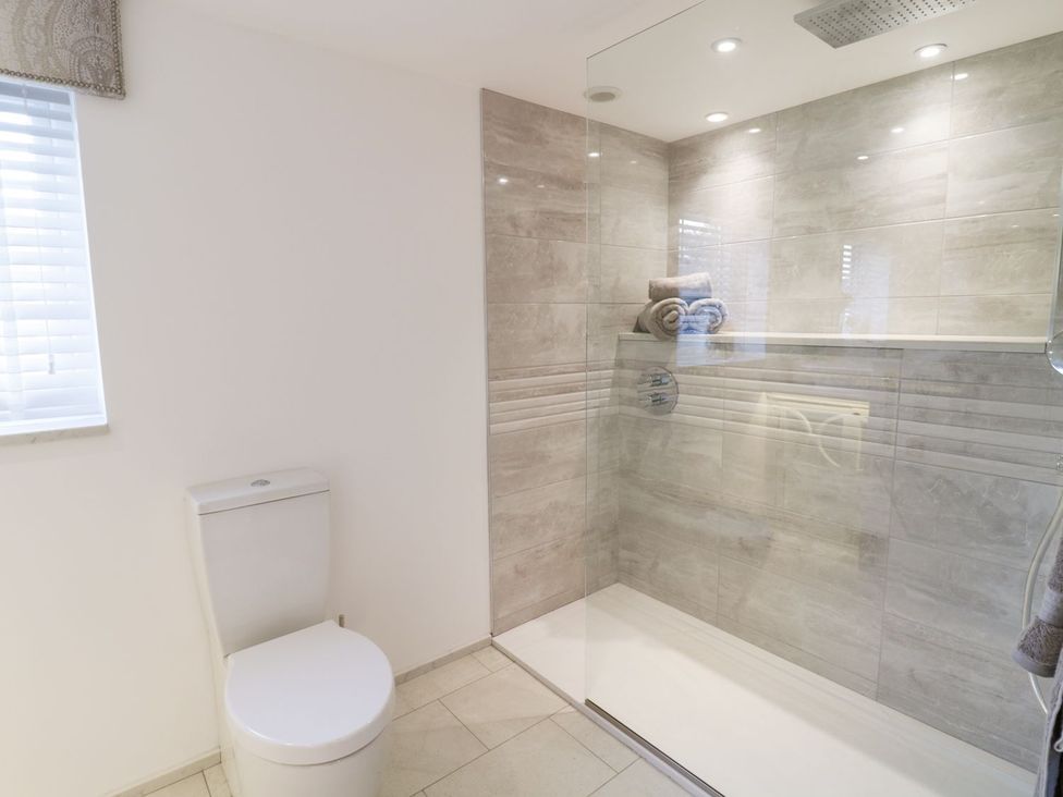 A bathroom with a toilet and a shower at 8 Crown Lane in Conwy