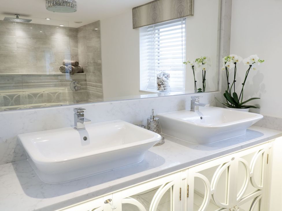 A bathroom with double sinks and a mirror at 8 Crown Lane Conwy