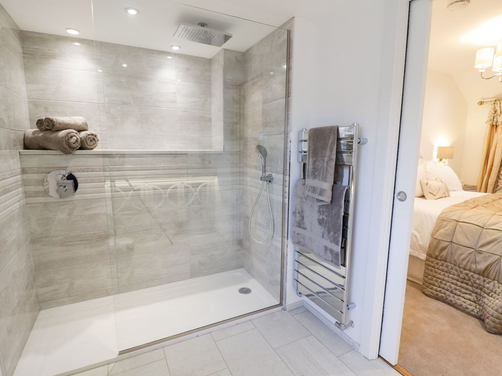 A bathroom with a shower and towels at 8 Crown Lane Conwy