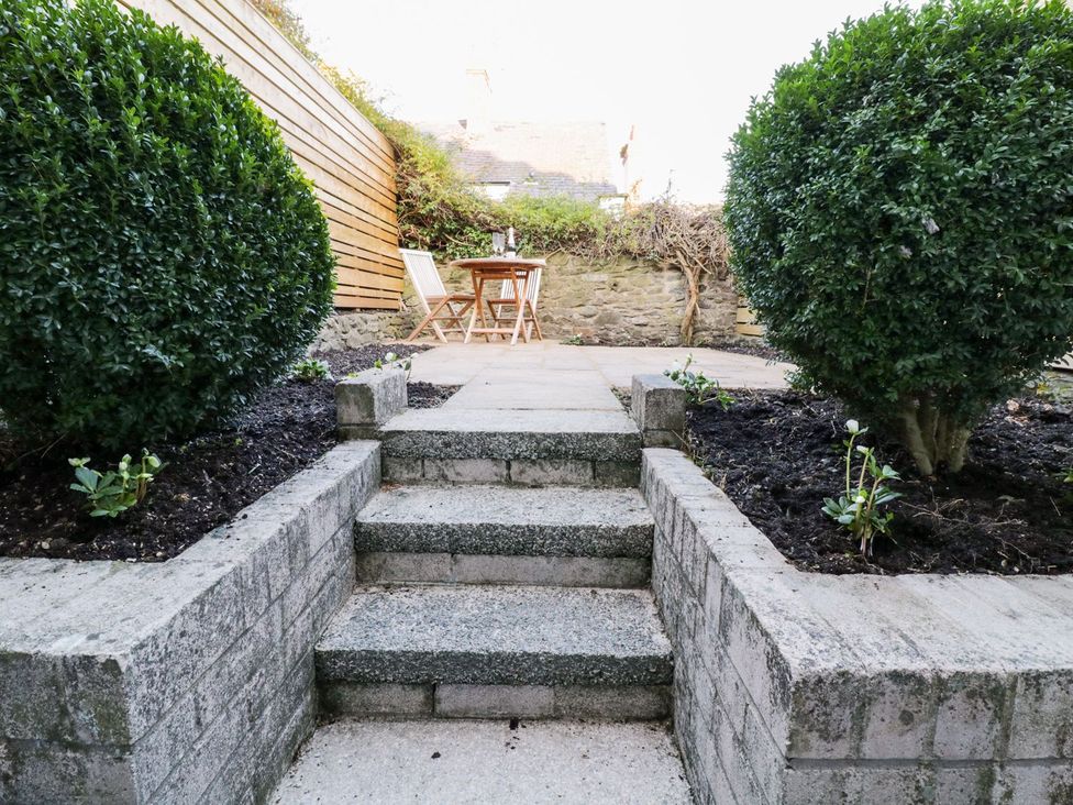 A garden with stone steps and seating area at 8 Crown Lane Conwy