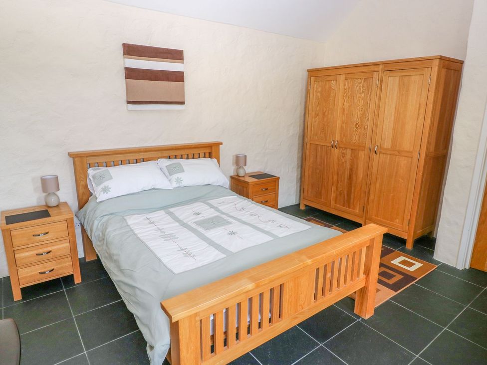A bedroom with wooden furniture and a bed at Maerdy Cwtch in Haverfordwest