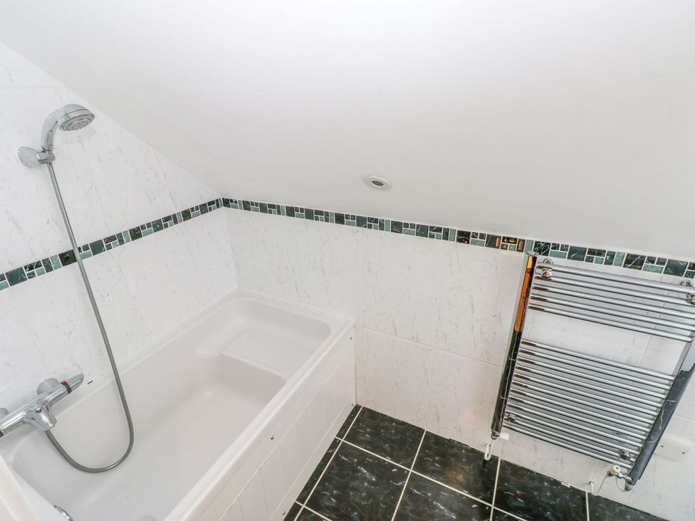 A bathroom with a bathtub and shower fixture at Maerdy Cwtch in Haverfordwest