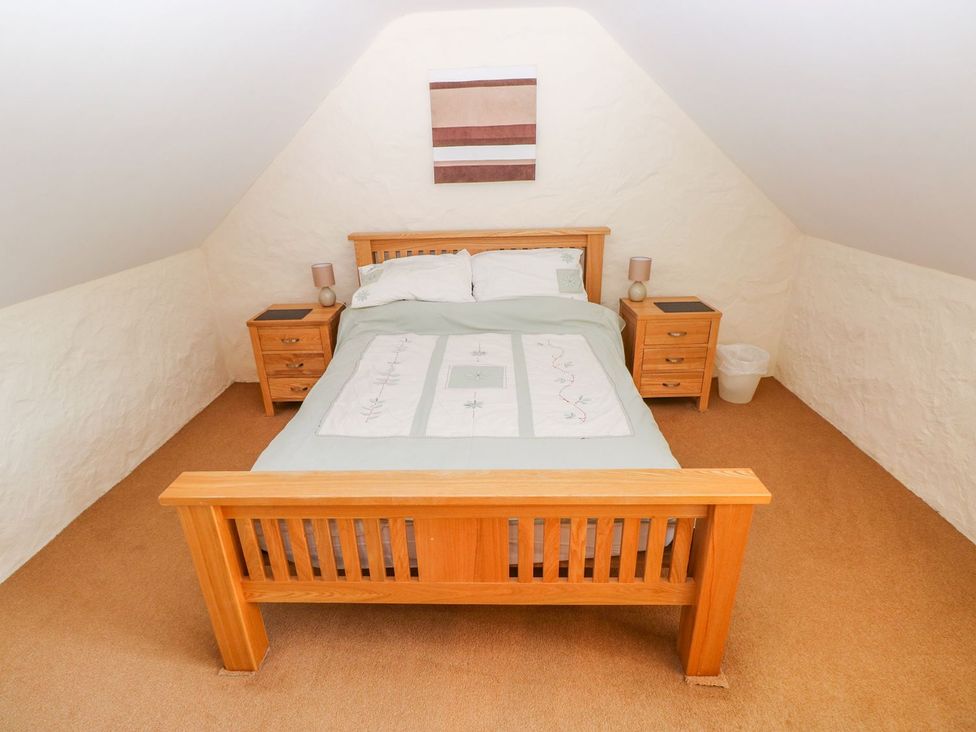 A bedroom with a bed and nightstands at Maerdy Cwtch in Haverfordwest