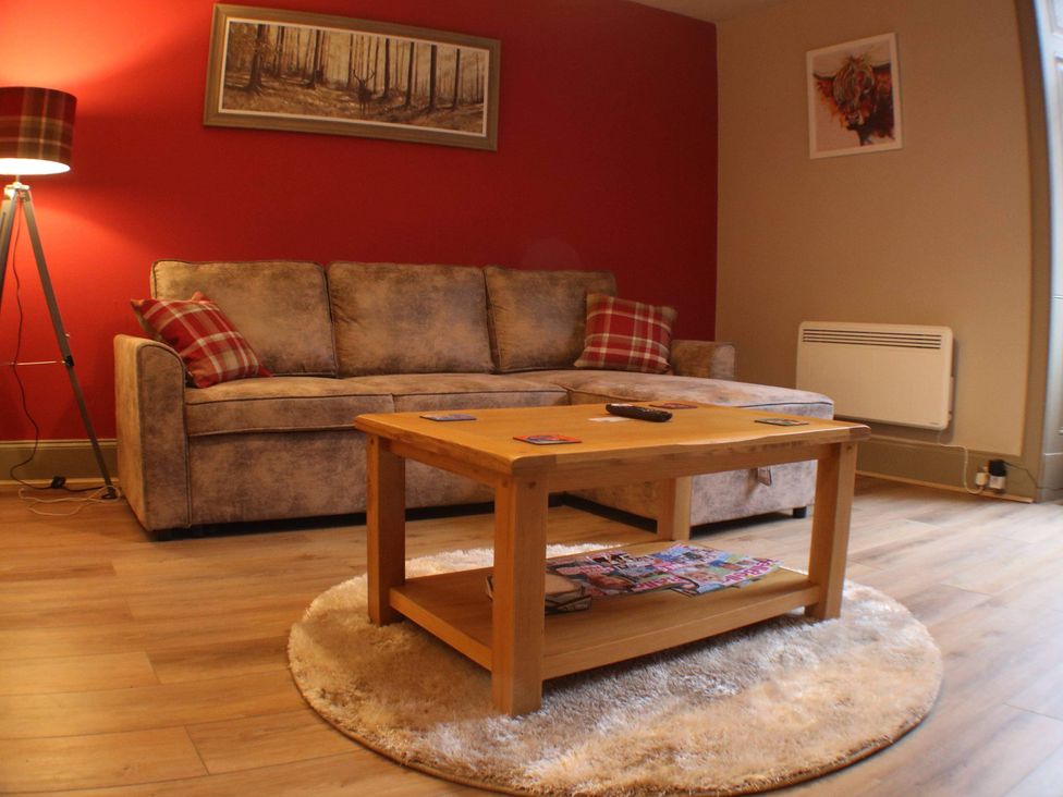 A living room with a sofa and coffee table at Stylish Highland retreat in the heart of town in Pitlochry
