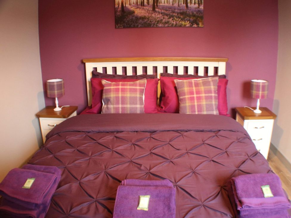 A bedroom with a bed and nightstand at Stylish Highland retreat in the heart of town, Pitlochry
