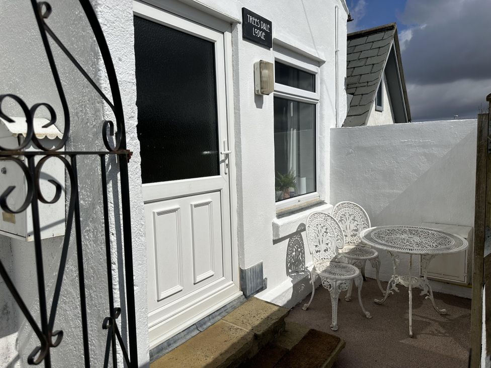 An outdoor area with a table and chairs at Treese Dale Lodge, Hayle
