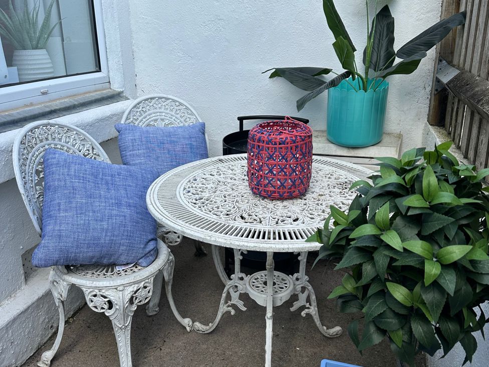 A outdoor seating area with a table and two chairs at Dog-friendly lodge, steps to St Ives train, Hayle