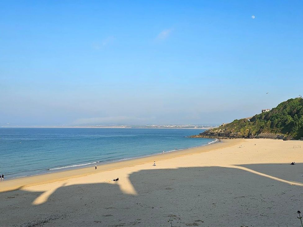A beach with ocean and hills at Dog-friendly lodge, steps to St Ives train in Hayle