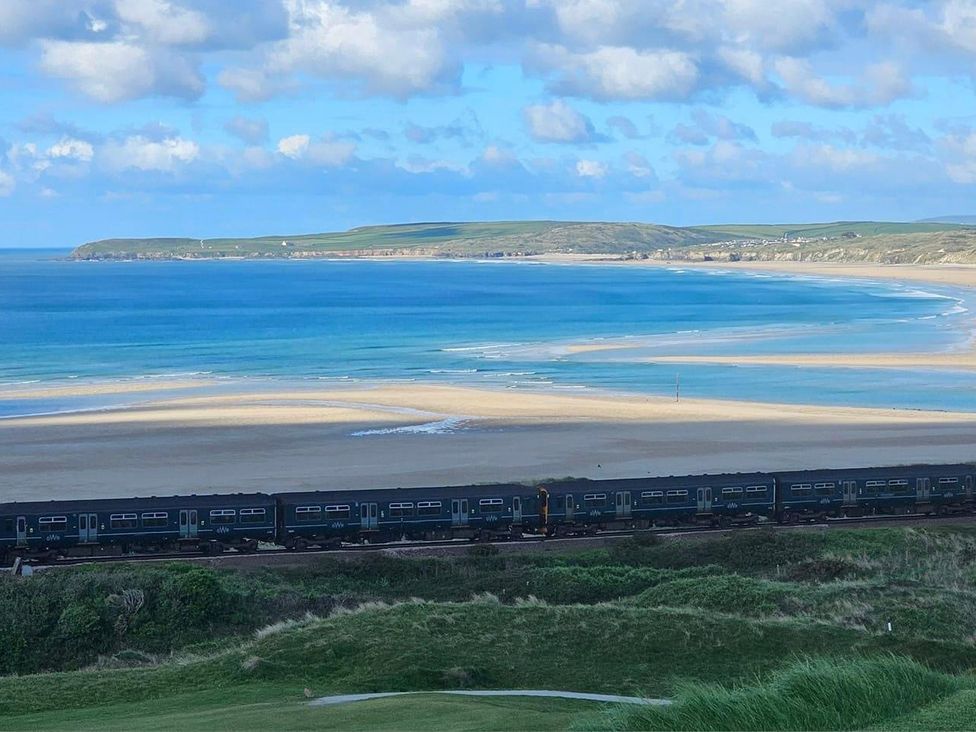 A view of the beach and ocean with a train in the foreground at Dog-friendly lodge, steps to St Ives train, Hayle