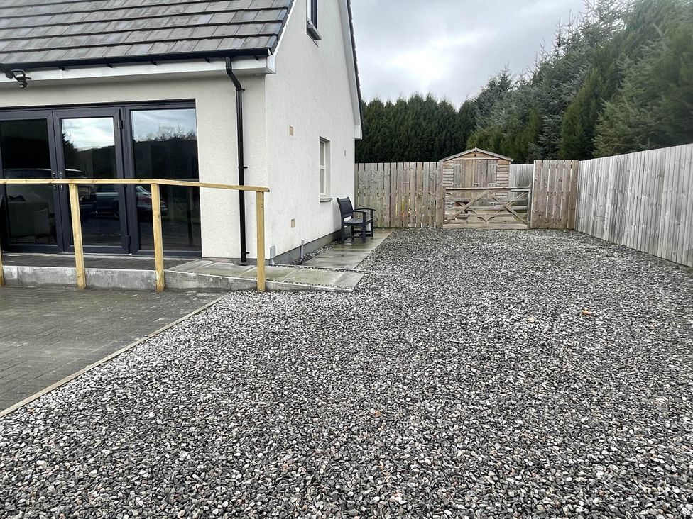 A garden area with gravel surface and a shed at Stylish NC500 base with panoramic views Inverness