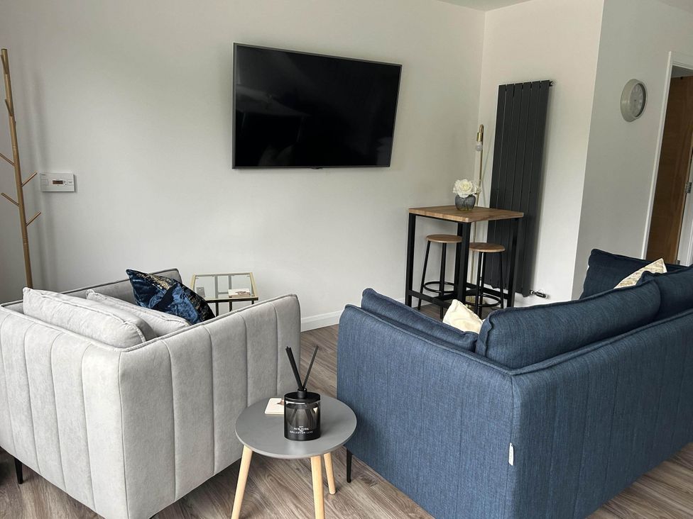 A living room with sofas, a television and a bar table at Stylish NC500 base with panoramic views Inverness