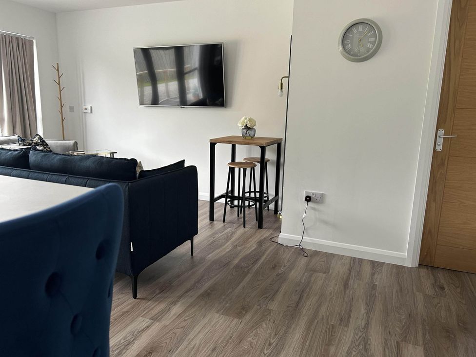 A living room with a sofa and television at Stylish NC500 base with panoramic views in Inverness