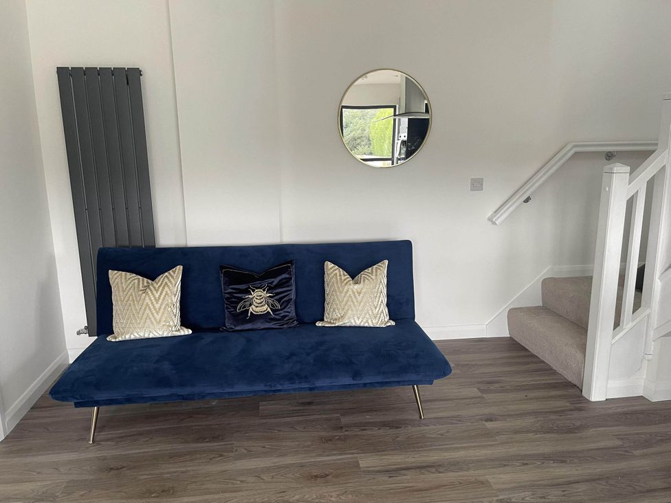 A living room with a blue sofa and decorative cushions at Stylish NC500 base with panoramic views Inverness