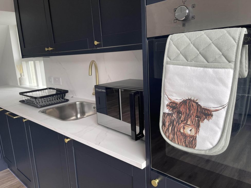 A kitchen with a sink and microwave at Stylish NC500 base with panoramic views Inverness