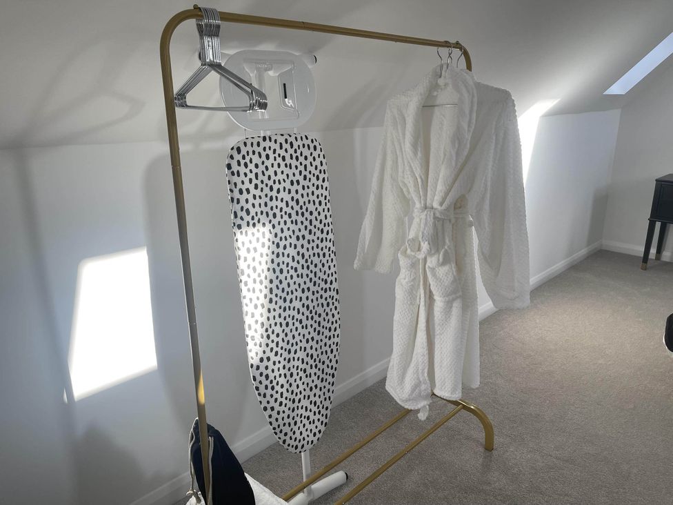A dressing room with an ironing board and a bathrobe at Stylish NC500 base with panoramic views Inverness